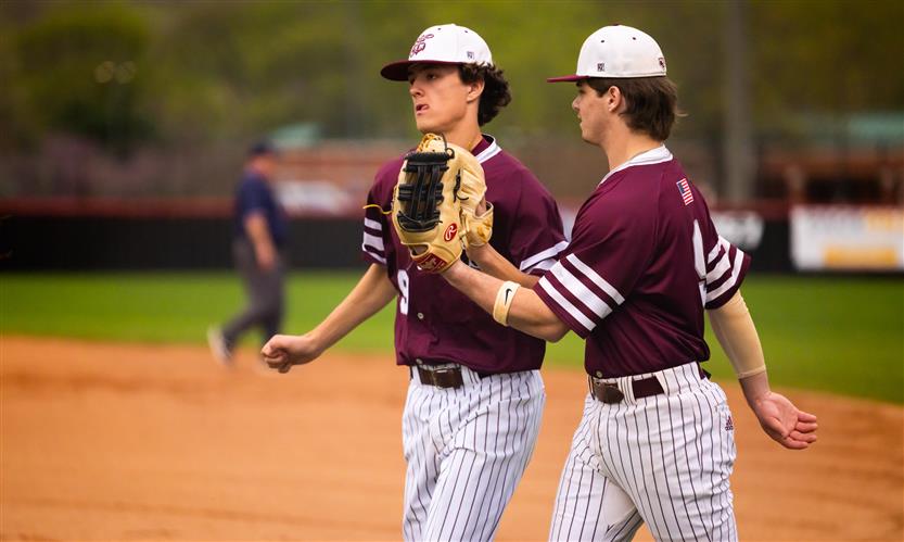 Two Franklin High baseball players high five on the field.